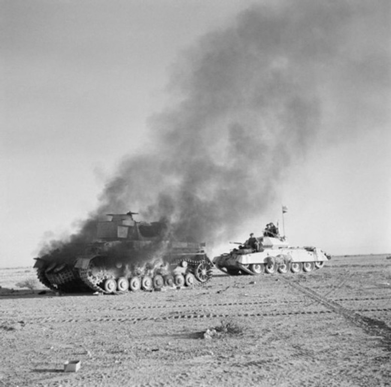 British Crusader Tank Passing a Burning German Tank