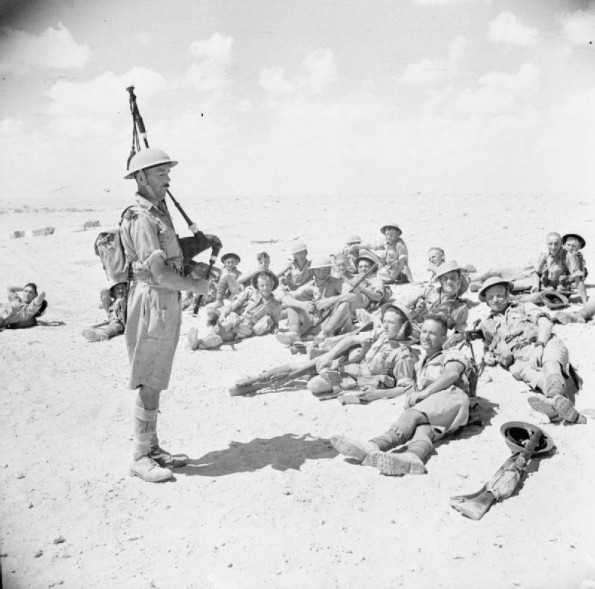 Piper Playing to Members of the Highland Division