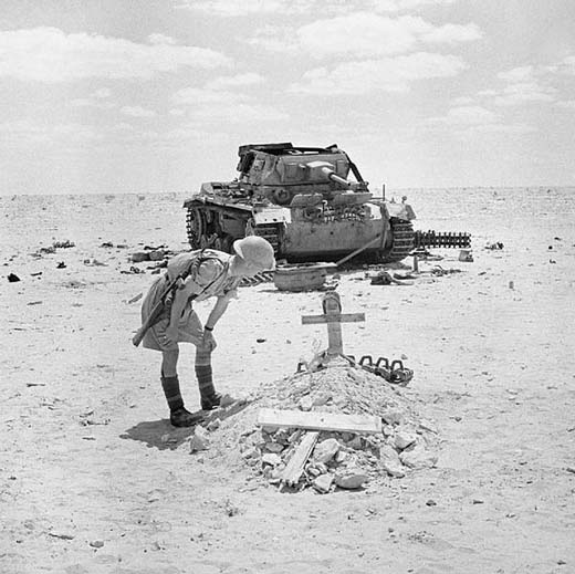 British soldier inspects the grave