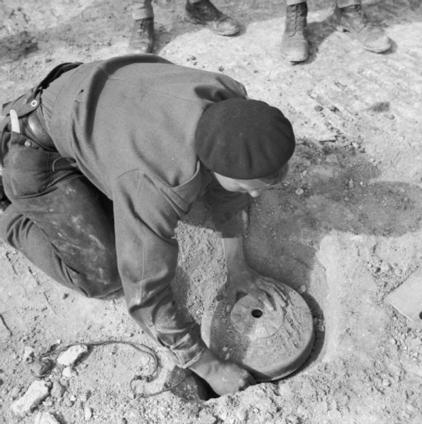 A Sapper Lifts a Mine