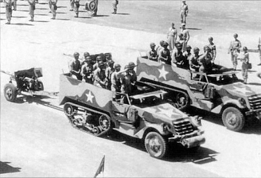 Camouflaged M3 Half-Tracks in a Parade