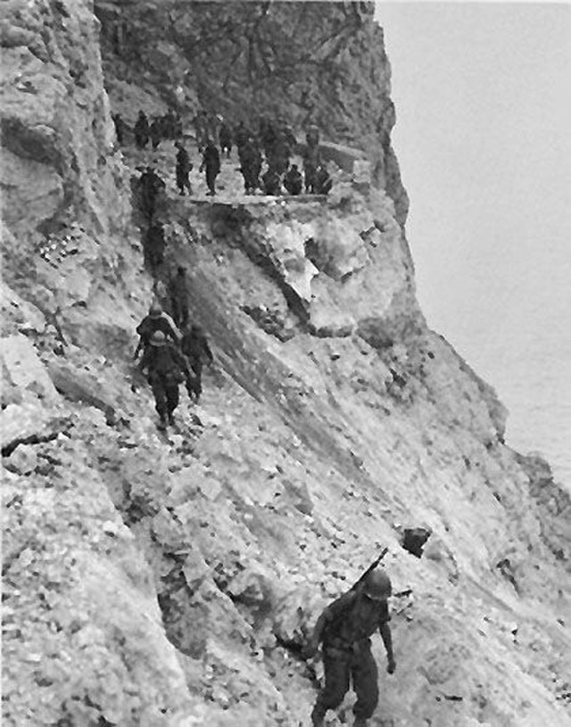 US Troops Moving around a Cliff