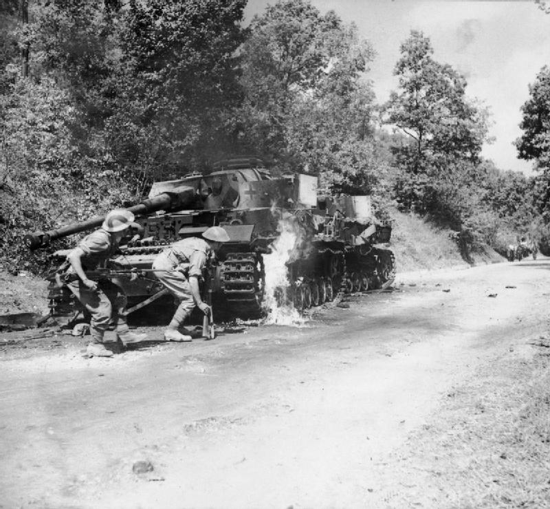 Allied Troops Pass Burning Tanks