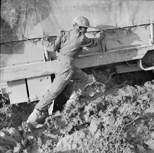 An Indian Soldier Pushing Vehicle in Deep Mud