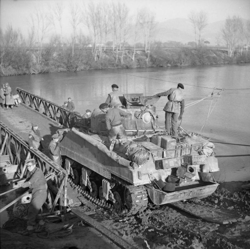 A Sherman tank drives onto a raft