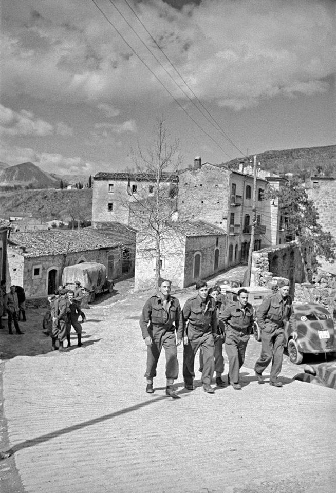 New Zealand soldiers stroll through a typical village