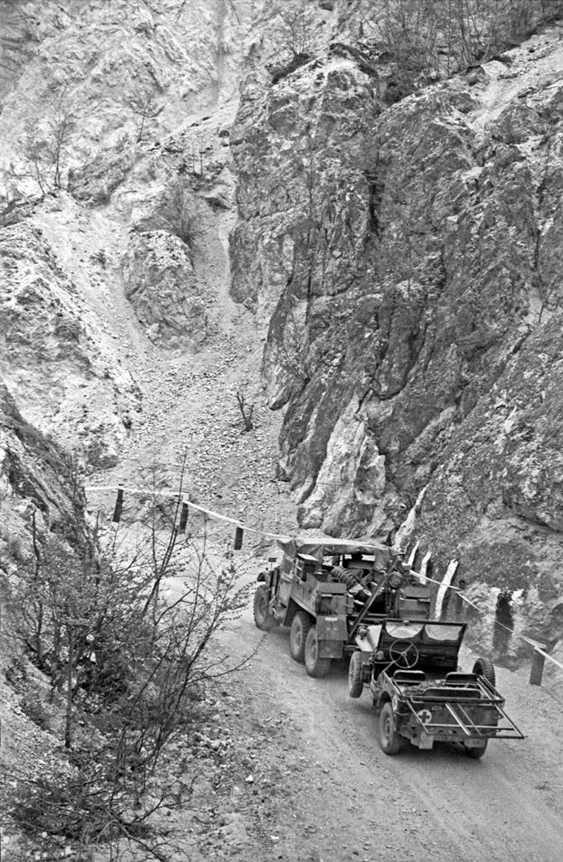 Military truck towing a jeep