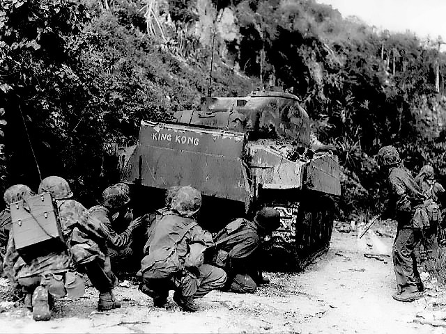 Marines Take Cover behind a M4 Sherman Tank