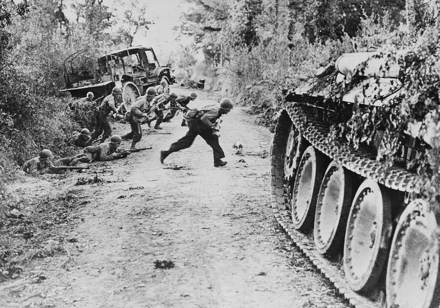 American soldiers race across a dirt road