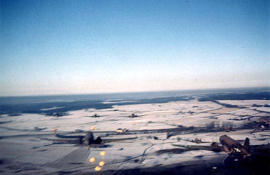 Parachutes over a snow covered Bastogne