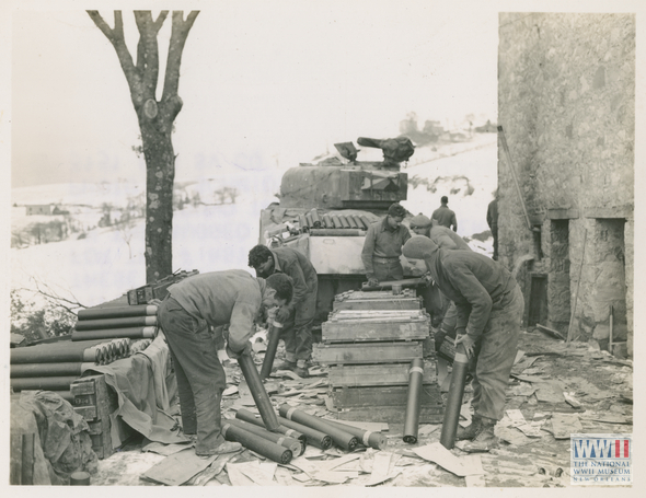 soldiers unpacking shell for tank